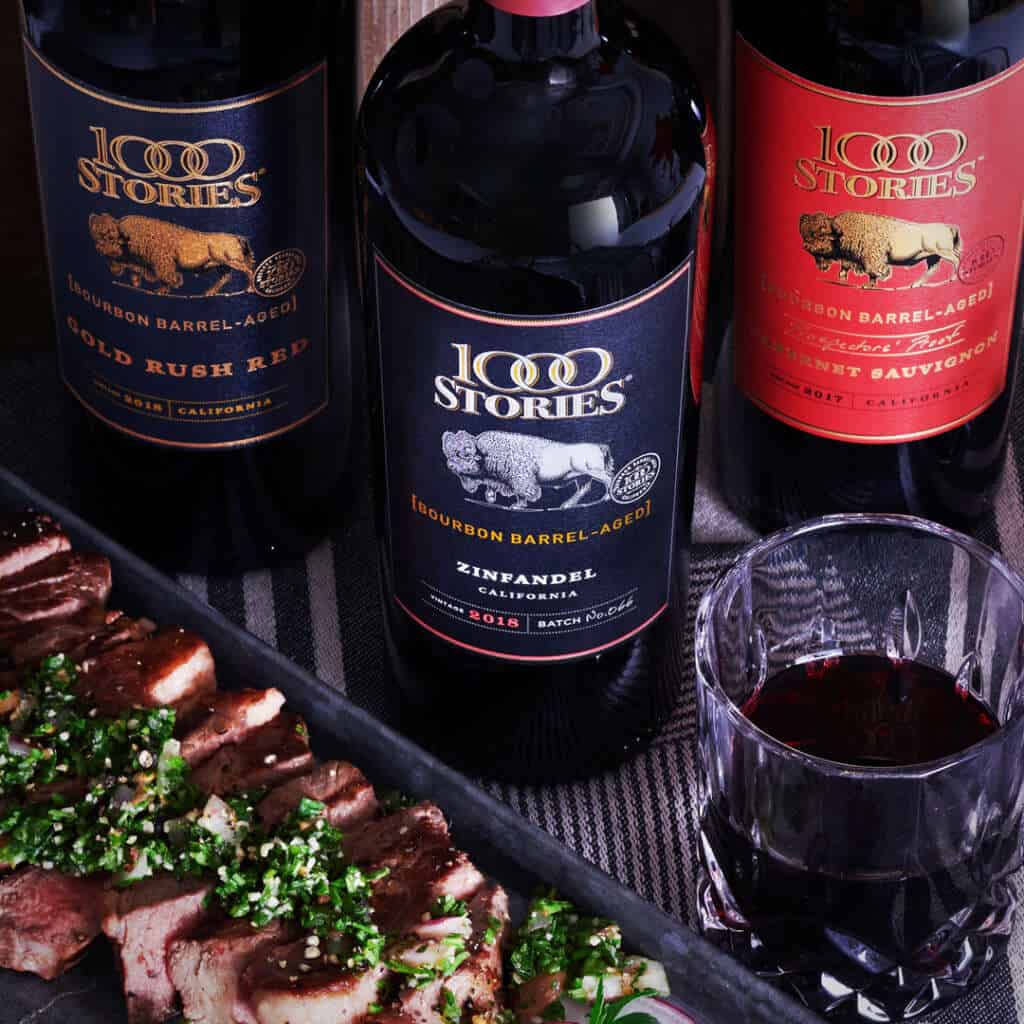 Delicious steak garnished with chimichurri sauce and paired with 1000 Stories red wines
